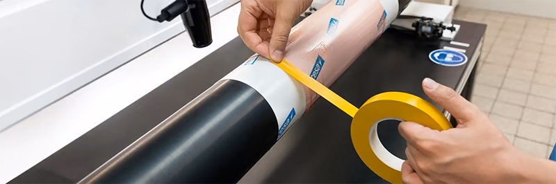Operator mounting a flexo plate with tesa Softprint tape